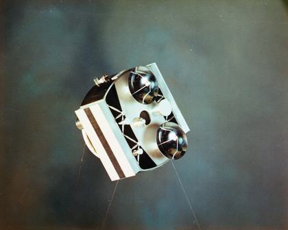 A model of an early research satellite with spherical sensors and a striped solar panel — early satellites like this helped scientists study the upper atmosphere and paved the way for modern space technology.